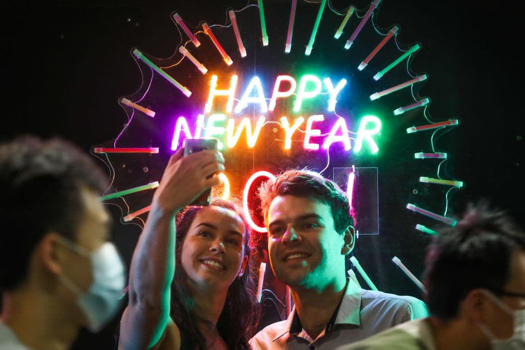En Melbourne, Australia, fue uno de los primeros lugares donde recibieron el Año Nuevo. Entre las celebraciones en la calle, las personas se hacen fotos frente a un cartel de neón de 'Feliz Año Nuevo'.