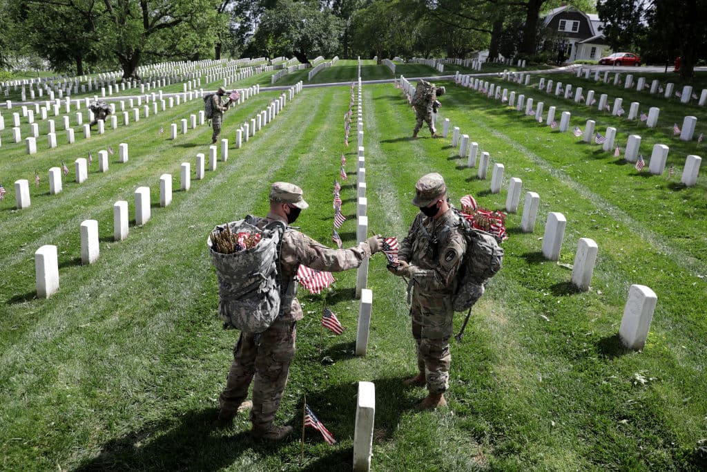 ARLINGTON, VIRGINIA - MAY 21: En Arlington, Virginia, soldados del Tercer Regimiento de Infantería colocan banderas en cada una de las tumbas y nichos, una tradición de esta celebración que recuerda a los estadounidenses caídos en las guerras.
