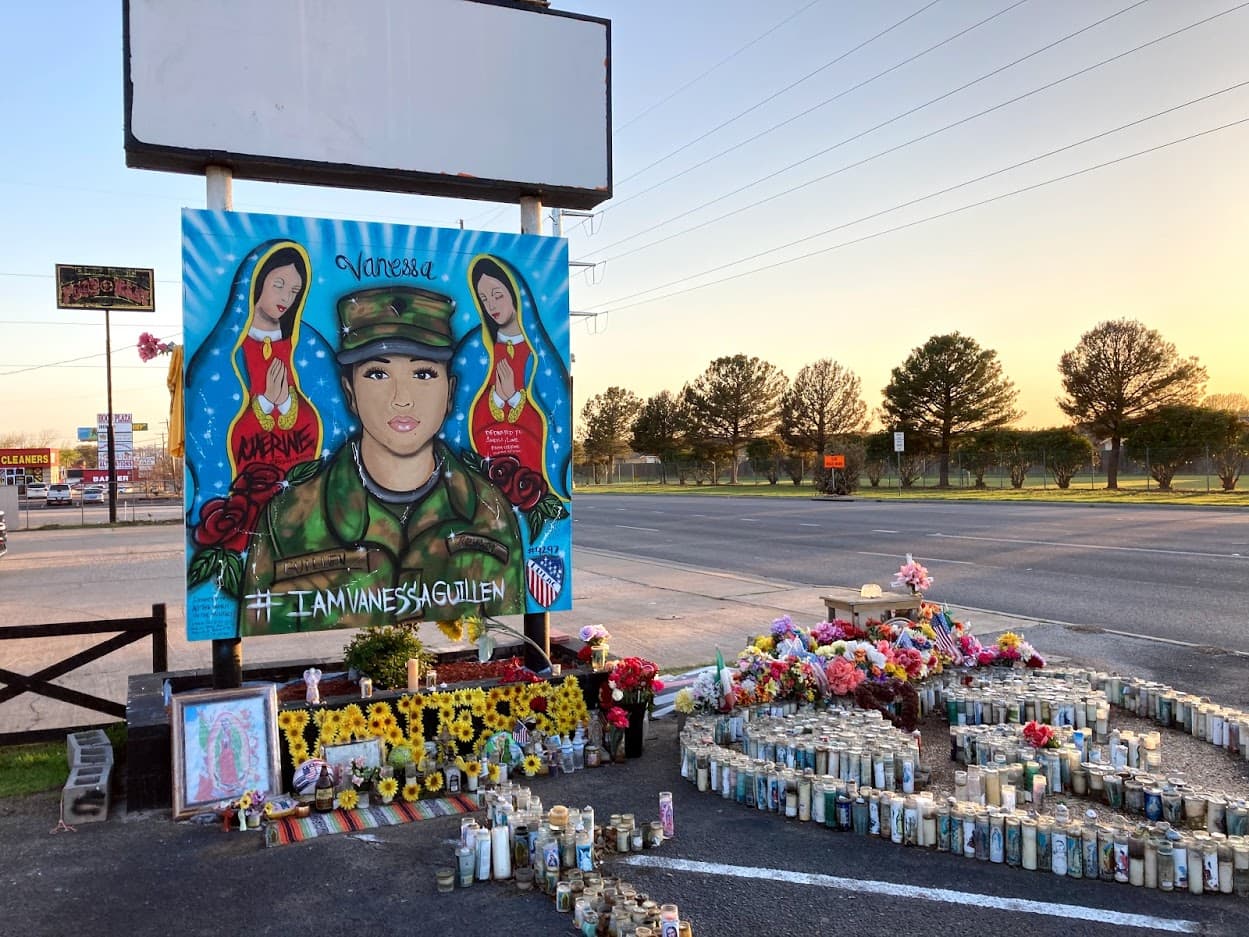 A mural honoring Vanessa Guillen near the entrance to the Fort Hood military base in Killeen, Texas, where she was killed is adorned with flowers and candles. On the back it contains hundreds of well-wishing messages.