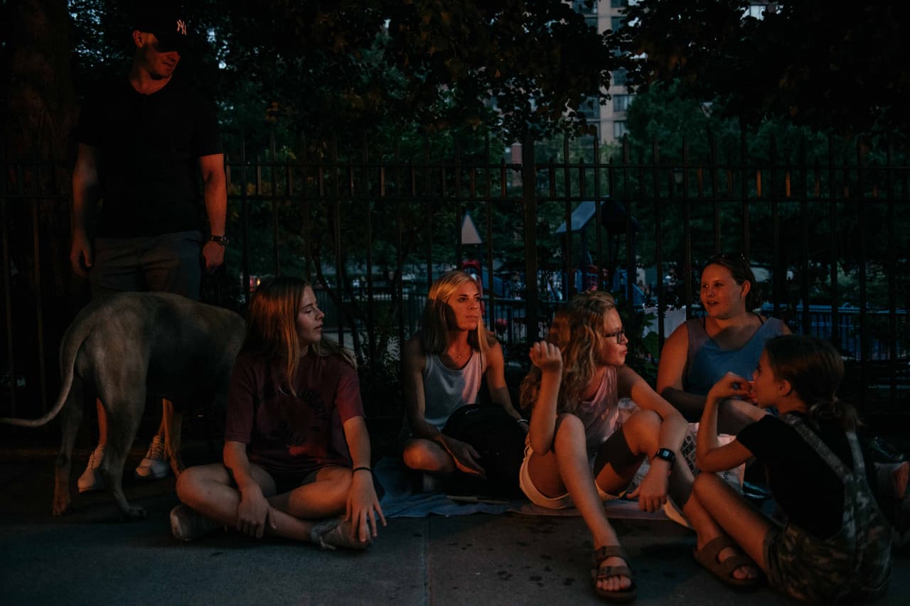 NUEVA YORK, NY - 13 DE JULIO: Ben Hunter, 40, extremo izquierdo, Addie Hunter, 15, Lori Hunter, 37, Lilli Hunter, 13, Bailey Rainey, 24, y Cami Hunter, 10, se sientan al otro lado de la calle de su edificio de apartamentos en la calle 64 Oeste después de haber perdido la electricidad durante un apagón importante el 13 de julio de 2019 en la ciudad de Nueva York. (Foto de Scott Heins/Getty Images)