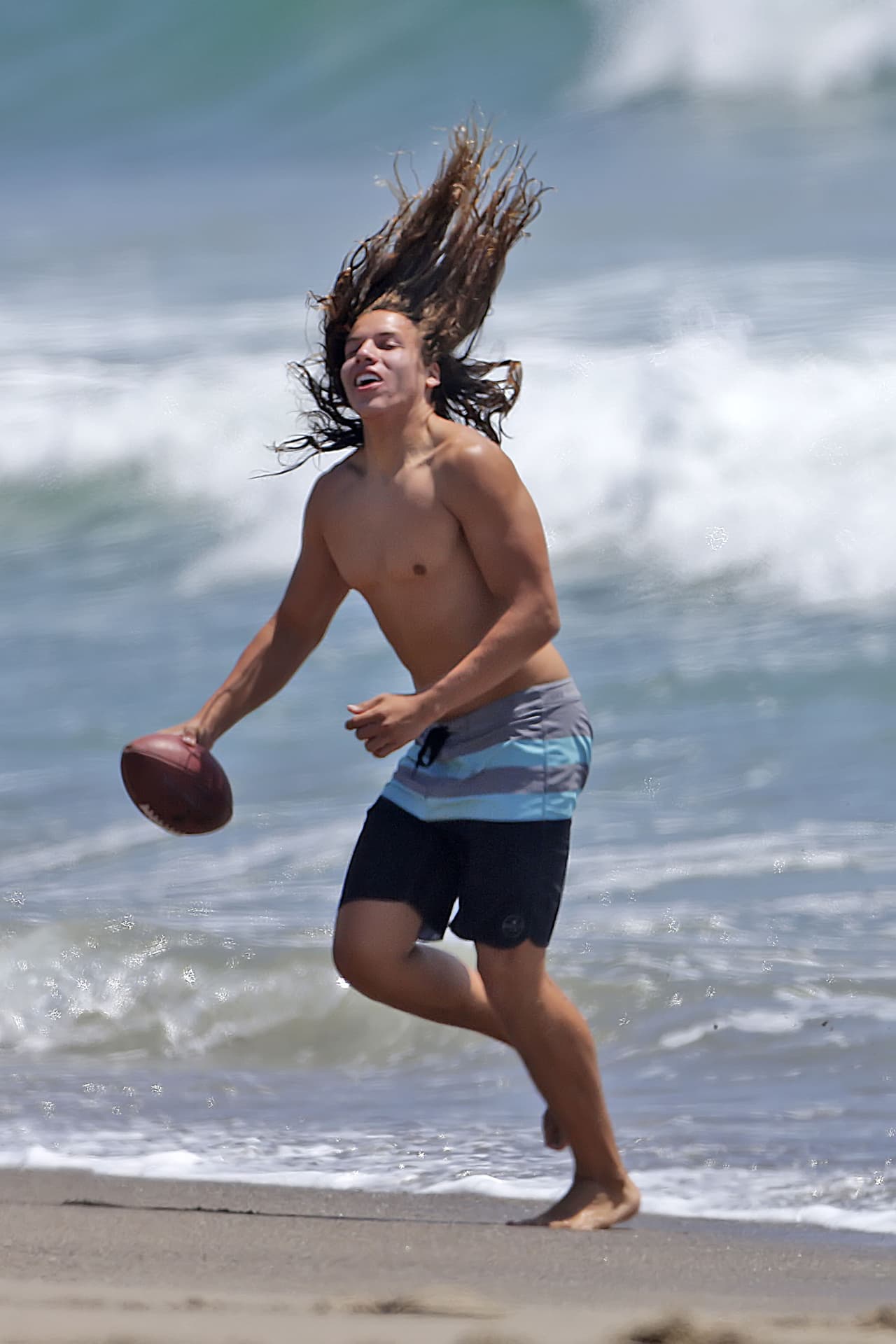 Joseph Baena, el hijo latino de Arnold, lanza un balón en la playa.