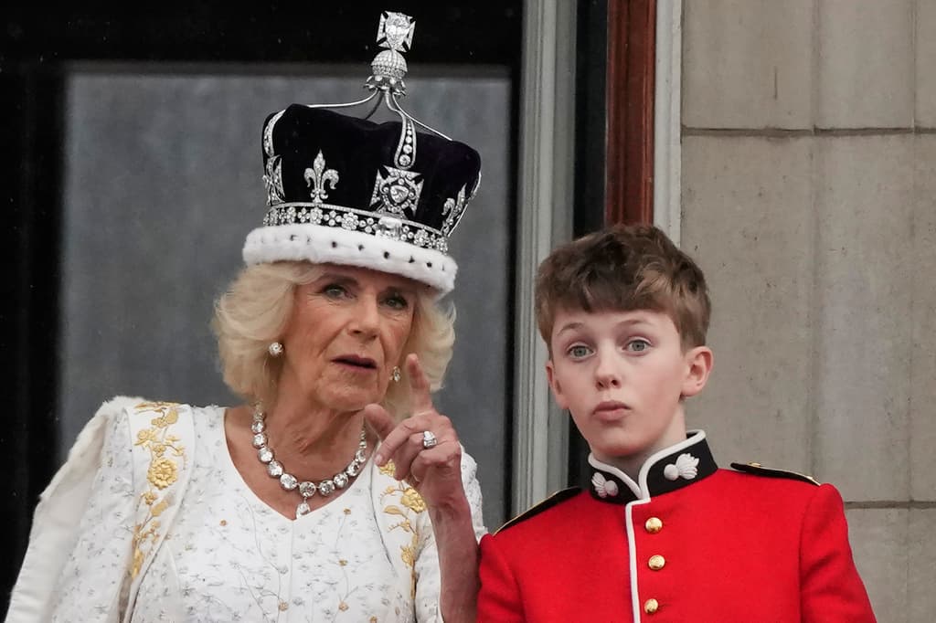 La reina Camila hace un gesto conversando con uno de sus pages durante el saludo desde el balcón del Palacio de Buckingham.