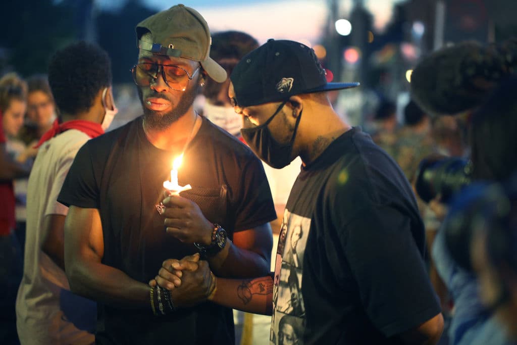 Gente enciende velas en el sitio donde murió Floyd.