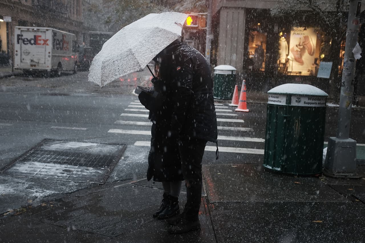 Una mujer bajo la nieve en una esquina de Manhattan, Nueva York.