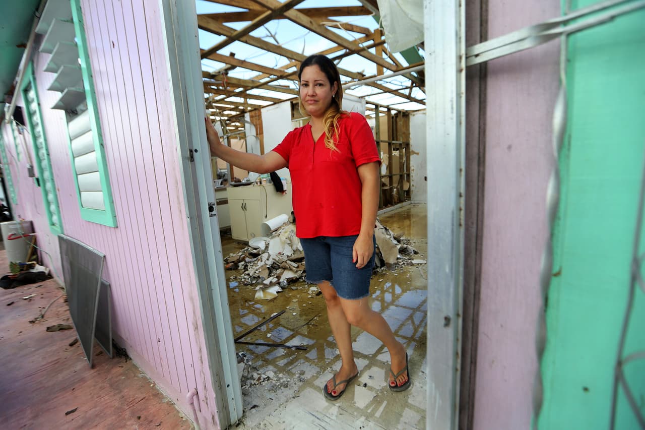 Sandy Nieves posa para un retrato en la puerta de su casa, muy dañada, después del huracán María en Yabucoa, Puerto Rico. Nieves dijo que su mayor necesidad es su hogar y especialmente la cama de su bebé. "No tenemos donde dormir, no tenemos nuestras cosas, todos estamos durmiendo en una cama en la casa de mi mamá".