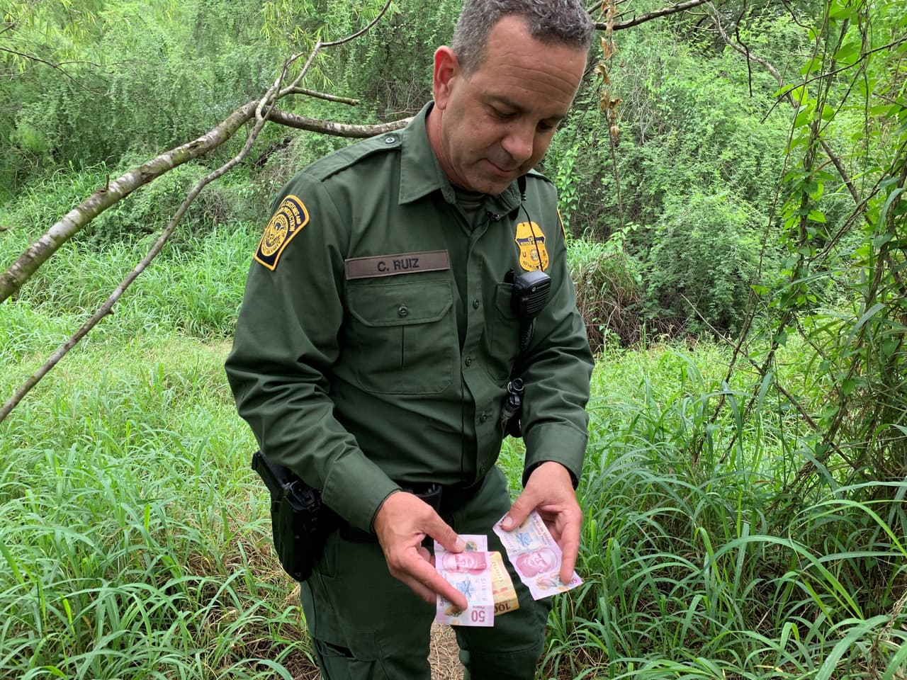 El oficial Carlos Ruíz, de la Patrulla Fronteriza en el sector del Valle del Rio Grande, enseña billetes de otros países que encuentra en los trayectos.