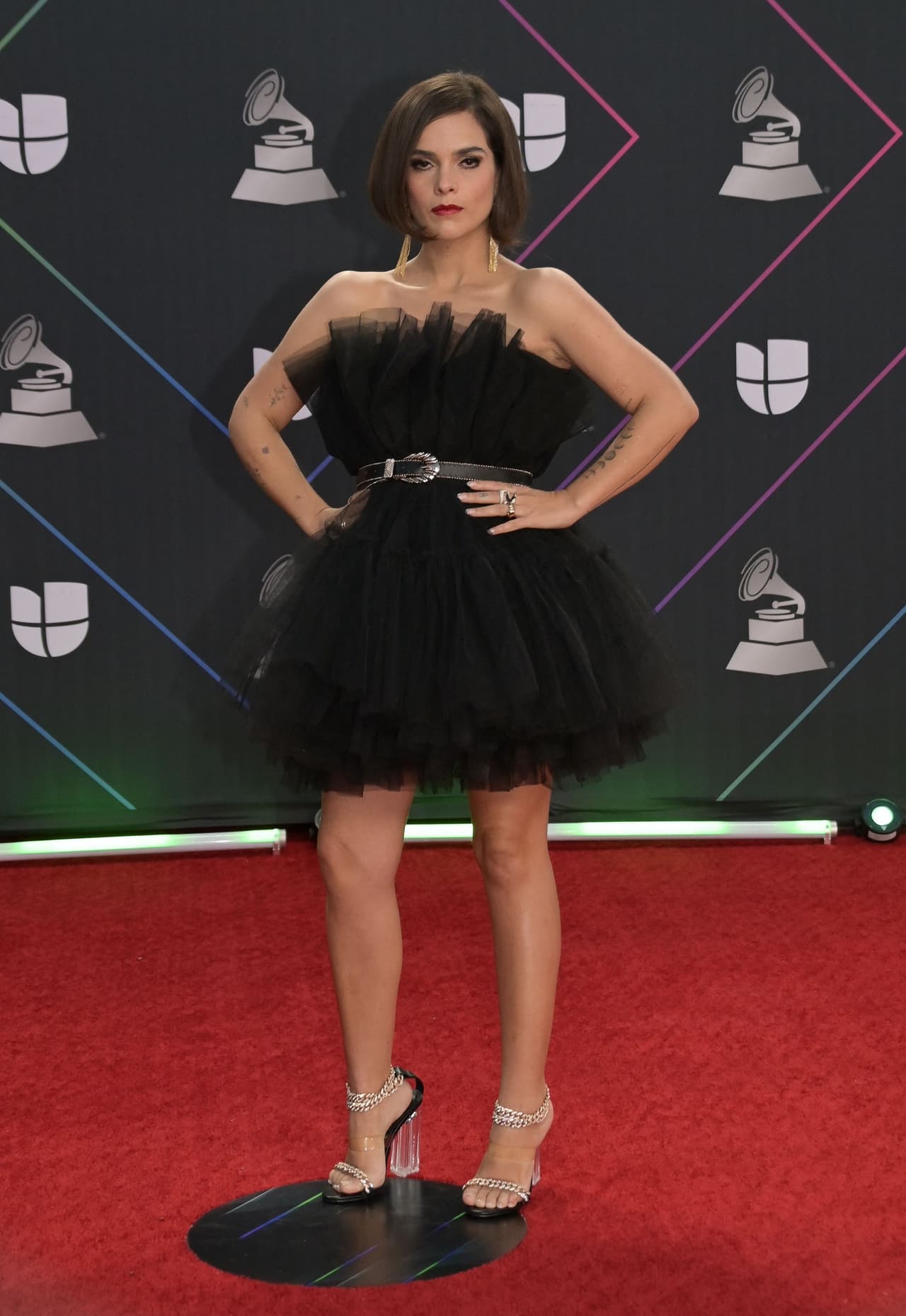 <b>Paula Arenas</b>
<br>La cantante lució un vestido corto de varias capas de tul negro que ajustó con un sencillo cinturón. Acompañó con unos zapatos de tacón transparente.