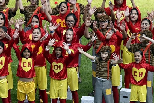 Un centenar de niños vestidos como Chapulín Colorado y el Chavo del Ocho entran al campo del estadio y le dedican una canción.