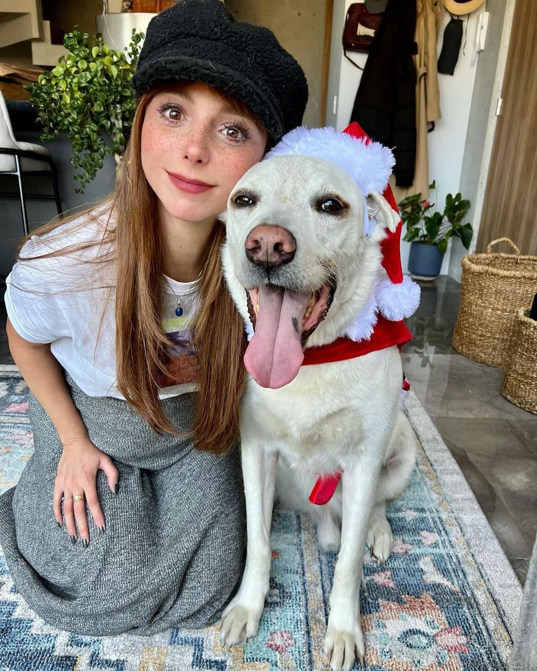 En Navidad de 2021, Natalia acompañó su look con una clásica boina negra y su cabello pelirrojo suelto. Su pancita luce debajo de su falda gris larga.