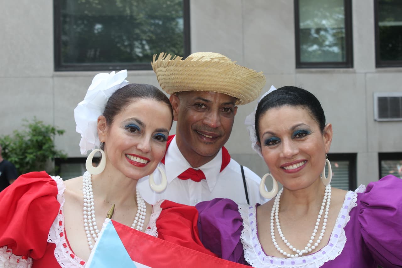 Bailaron 'un seis', una danza típica boricua en la apetura del desfile. Específicamente un seis con la canción Amanecer Borincano. De ahí se congregaron cerca de la calle 70 para ver el evento en un segundo plano. “Somos nacidos y criados en PR, trabajamos acá y en nuestro tiempo libre participamos en un grupo folclórico. Representamos la cultura de PR acá en NY”, relató Noelia Torres (izquierda) del montañoso pueblo de Lares, en el centro de la isla. A su lado, Alexis Roque y Mabel Mercado, de Ponce. Patricia Vélez/Univision Noticias)