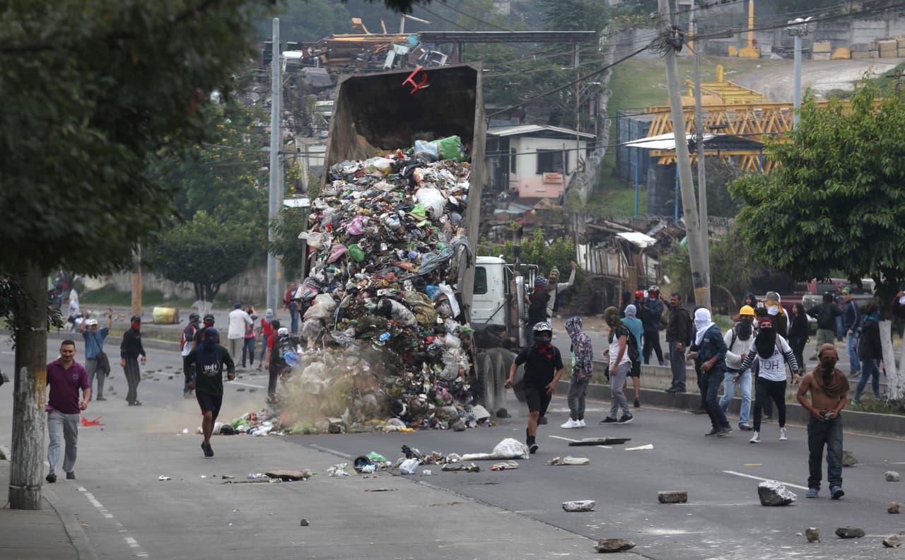 Manifestantes tiran la basura de un camión recolector para bloquear una calle de Tegucigalpa. Las fuerzas de seguridad hondureñas se enfrentan con opositores que exigen un conteo detallado de los votos. El gobierno asegura que el proceso electoral fue transparente y que aceptará el resultado definitivo que dé el árbitro electoral, pese a las dudas expresadas por algunos entes internacionales como la Organización de Estados Americanos (OEA).
