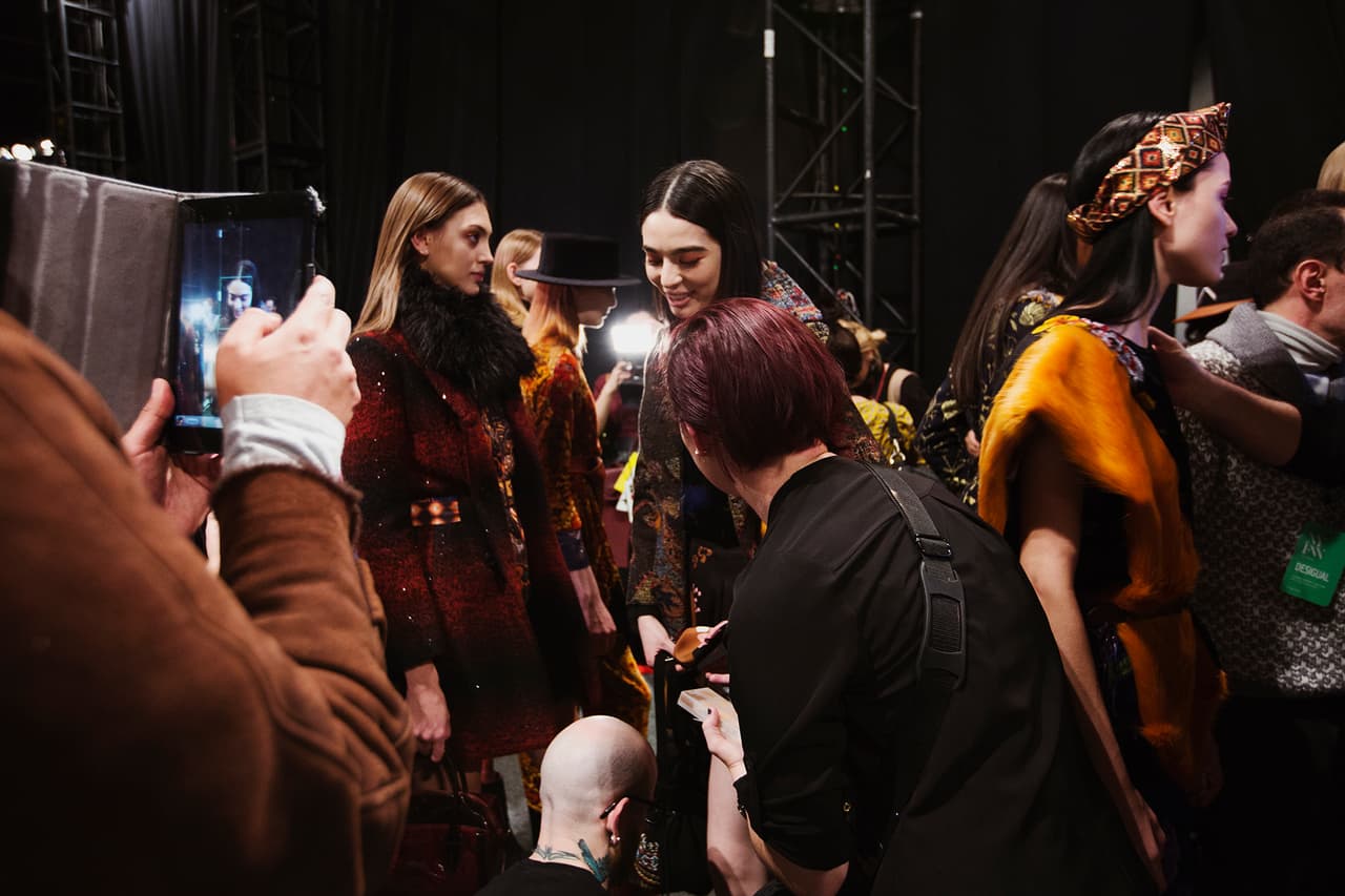 Una vez el maquillaje está finalizado es hora de vestirse. En el backstage, hay un rack para cada modelo con cada una de las piezas que va a usar y en el orden en las que debe ponérselas. Aquí algunas asistentes de la marca ayudándole a Cristina a finalizar detalles.