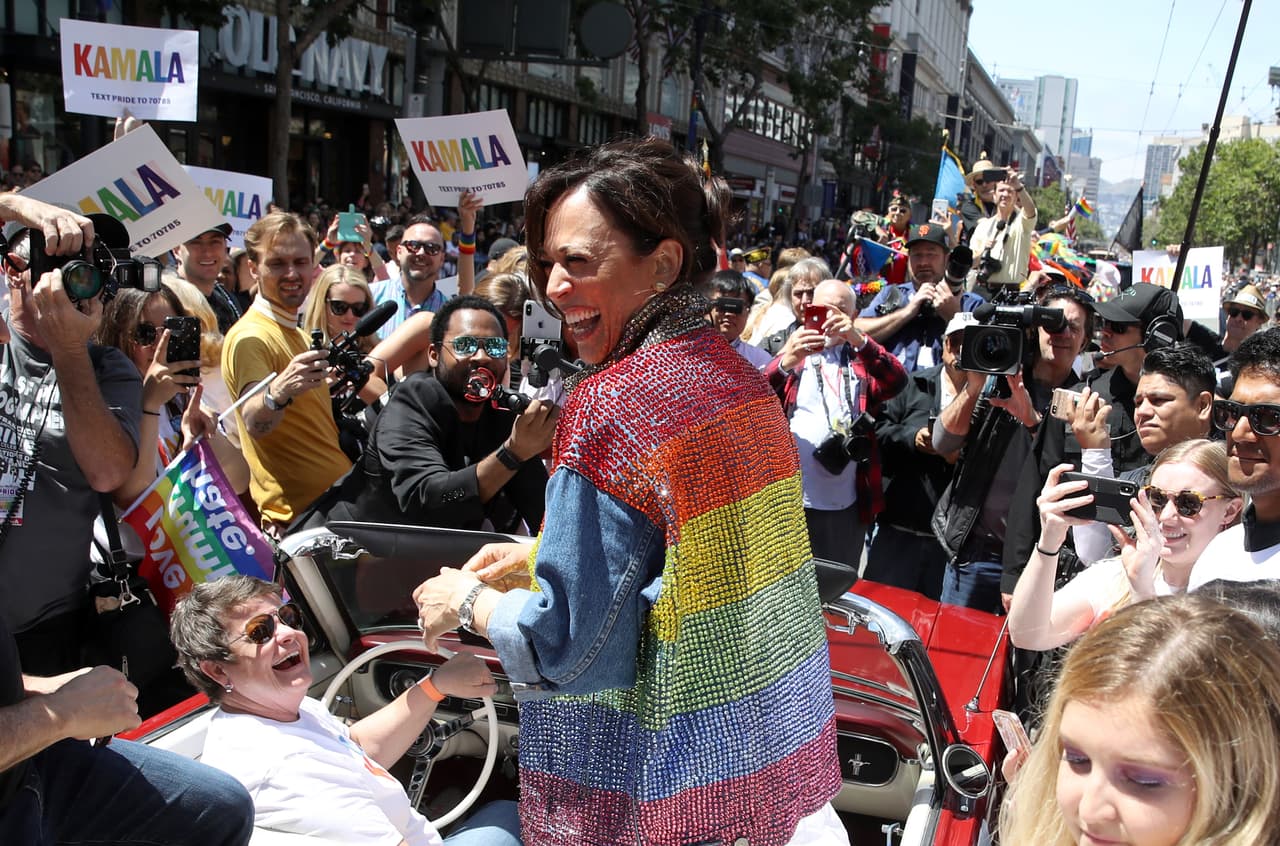 En esta foto se puede ver a la candidata presidencial demócrata, Kamala Harris, riéndose mientras viaja en un auto por las calles de la ciudad durante el desfile del orgullo.
<br>