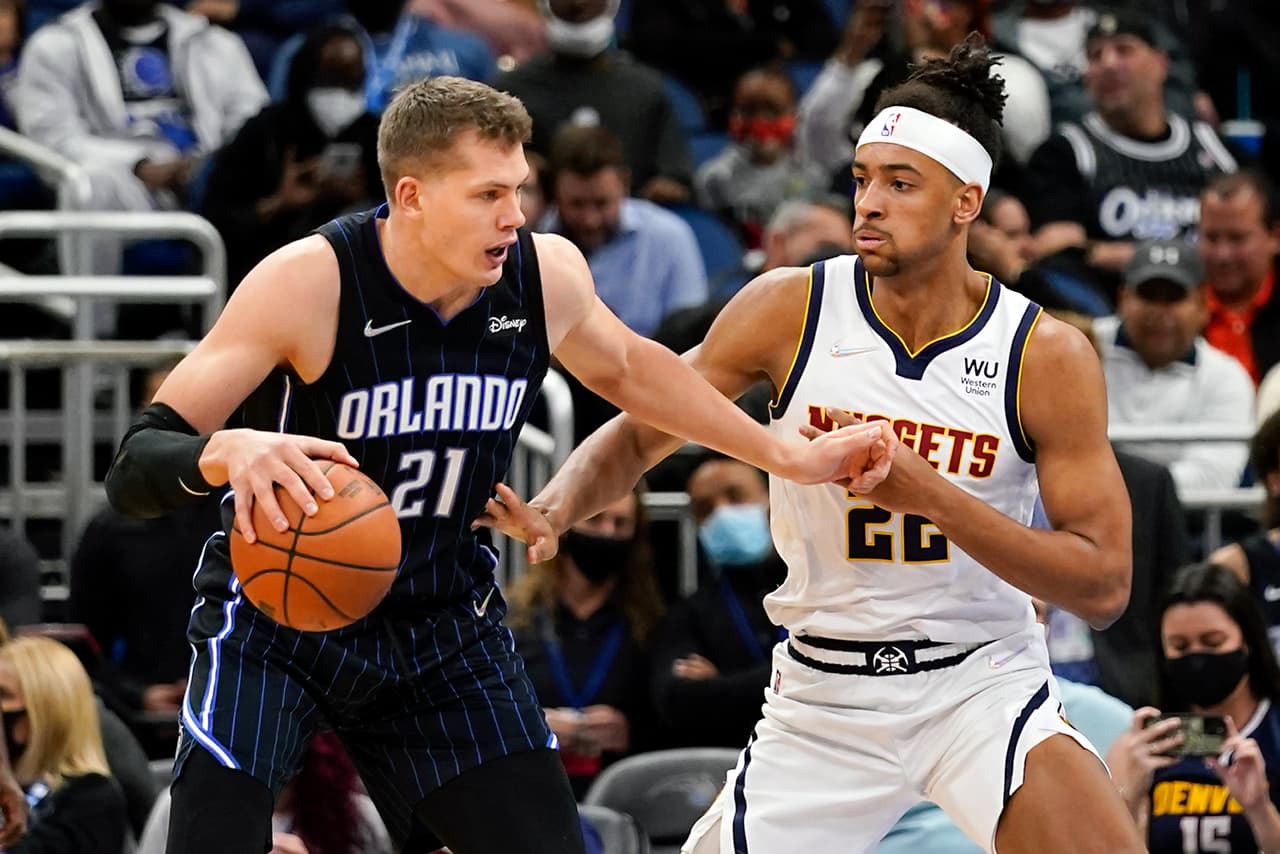 Moritz Wagner (21) de los Magic de Orlando con el balón marcado por Zeke Nnaji de los Nuggets.