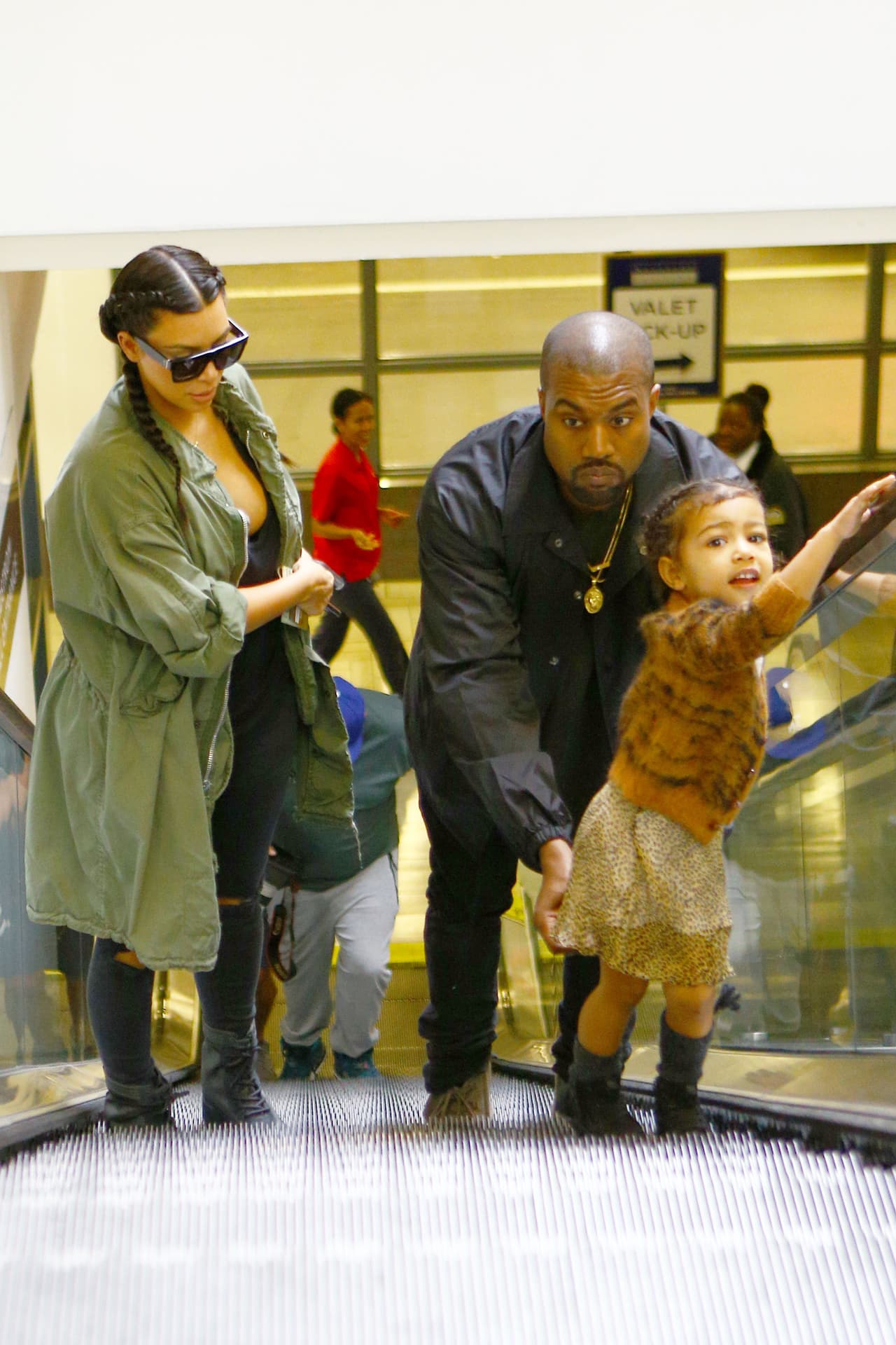 Llegó el turno de que Kanye la cuidara en otras escaleras eléctricas.