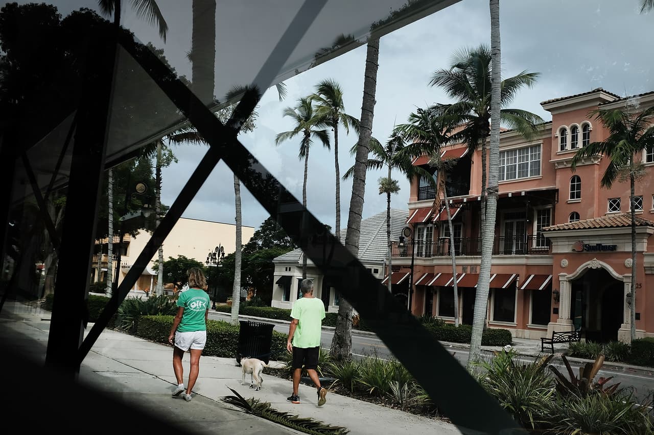People walk in the empty center of Naples, popular with wealthy retirees. Not far from Naples is the agricultural community of Immokolee, producing tomatoes, where 70 percent of the population is Hispanic.