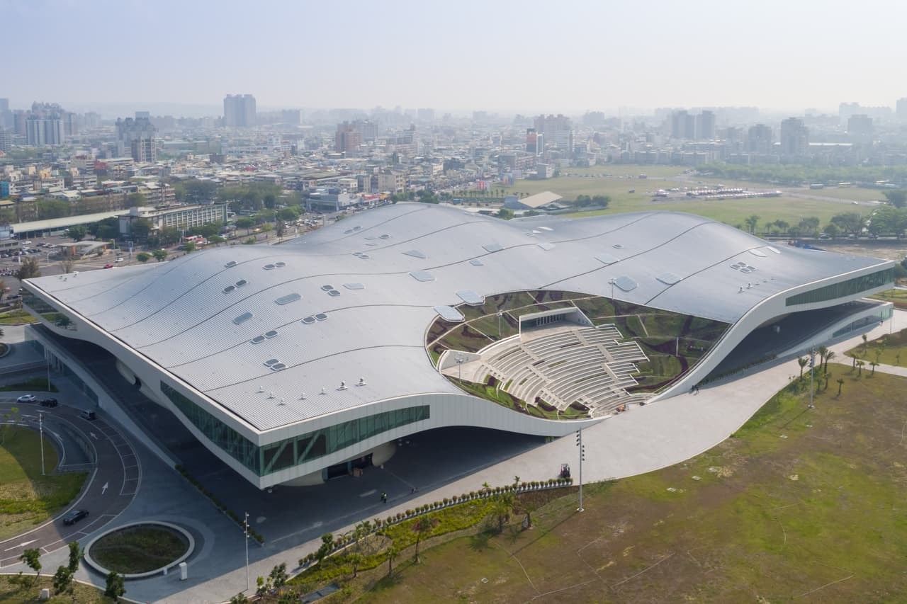 <b>Centro Nacional para las Artes de Kaohsiung</b>. Está situado en un antiguo terreno militar de Kaohsiung, Taiwán, y forma parte del parque adyacente. Su diseño, realizado por el
<a href="http://www.mecanoo.nl"> <u>estudio Mecanoo</u></a>, está inspirado en los árboles de banano locales. La vasta y ondulada estructura de acero sale en su nivel superior hacia un escenario al estilo griego, que baja suavemente hacia el suelo. Los organizadores del
<a href="https://www.worldarchitecturefestival.com"> <u>premio WAF</u></a> han recibido en esta edición más de 1,000 proyectos provenientes de 70 países.