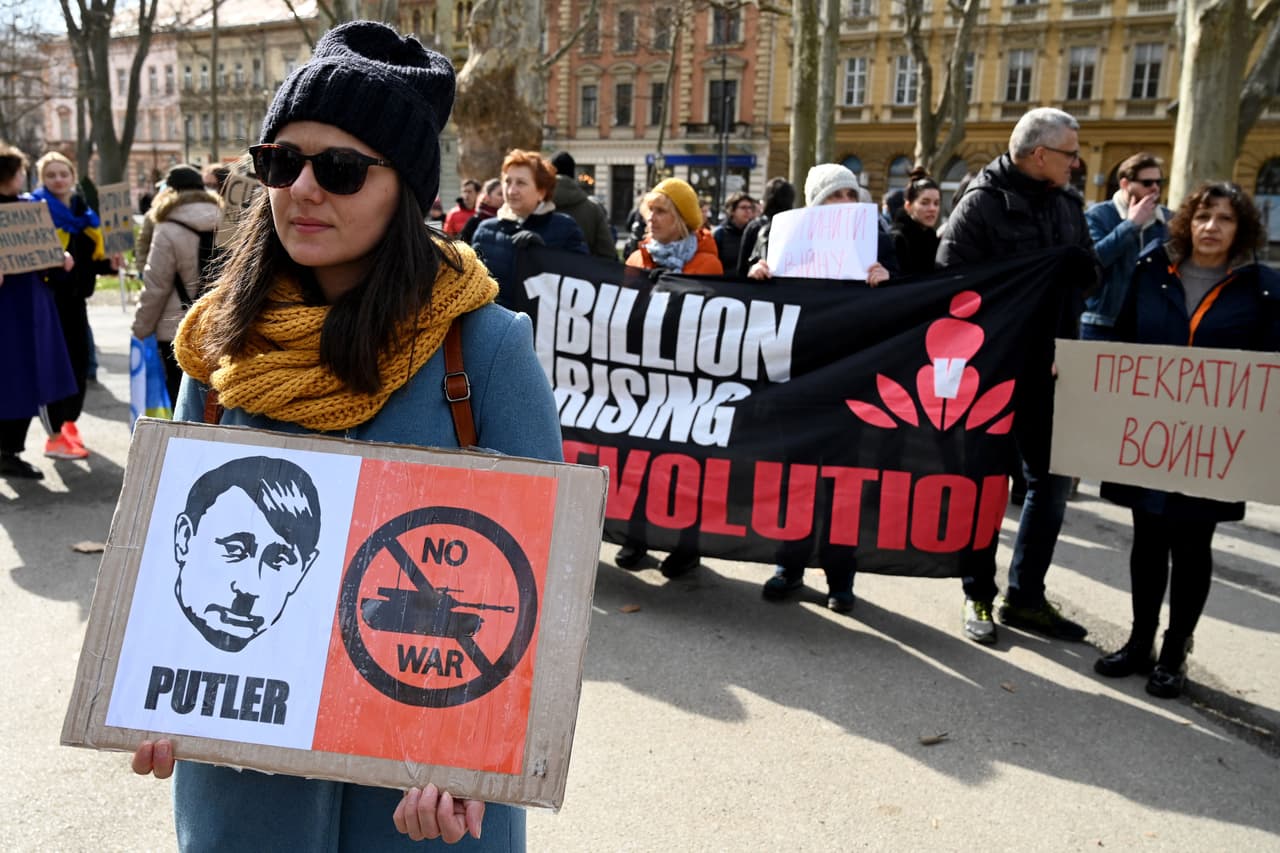 Una mujer sostiene una pancarta con
<b>un personaje que fusiona la cara de Putin y la de Hitler </b>durante una protesta contra la invasión rusa de Ucrania en Zagreb, Croacia.