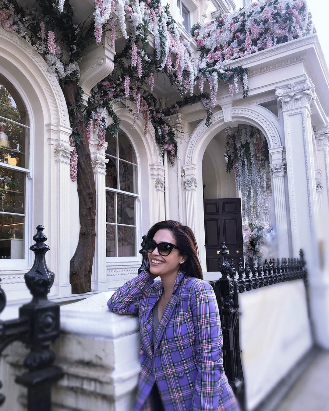 En su último viaje a Europa, la conductora mexicana incorporó en sus looks de viaje un abrigo color lavanda con el estampado escocés.