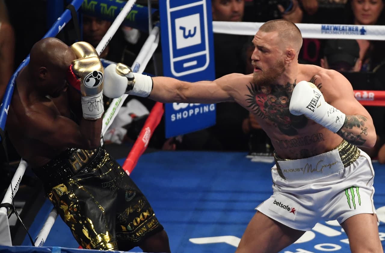 LAS VEGAS, NV - AUGUST 26: (R-L) Conor McGregor throws a punch at Floyd Mayweather Jr. during their super welterweight boxing match on August 26, 2017 at T-Mobile Arena in Las Vegas, Nevada. (Photo by Ethan Miller/Getty Images)
