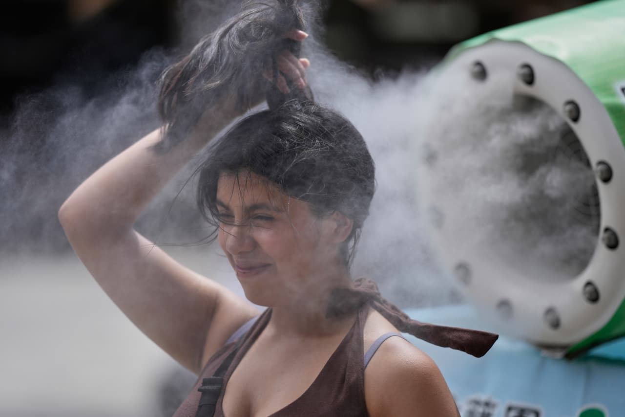Una persona se refresca en un punto de nebulización durante un día caluroso y soleado en el templo budista Sensoji, en el distrito de Asakusa de Tokio, el viernes 7 de agosto de 2026.