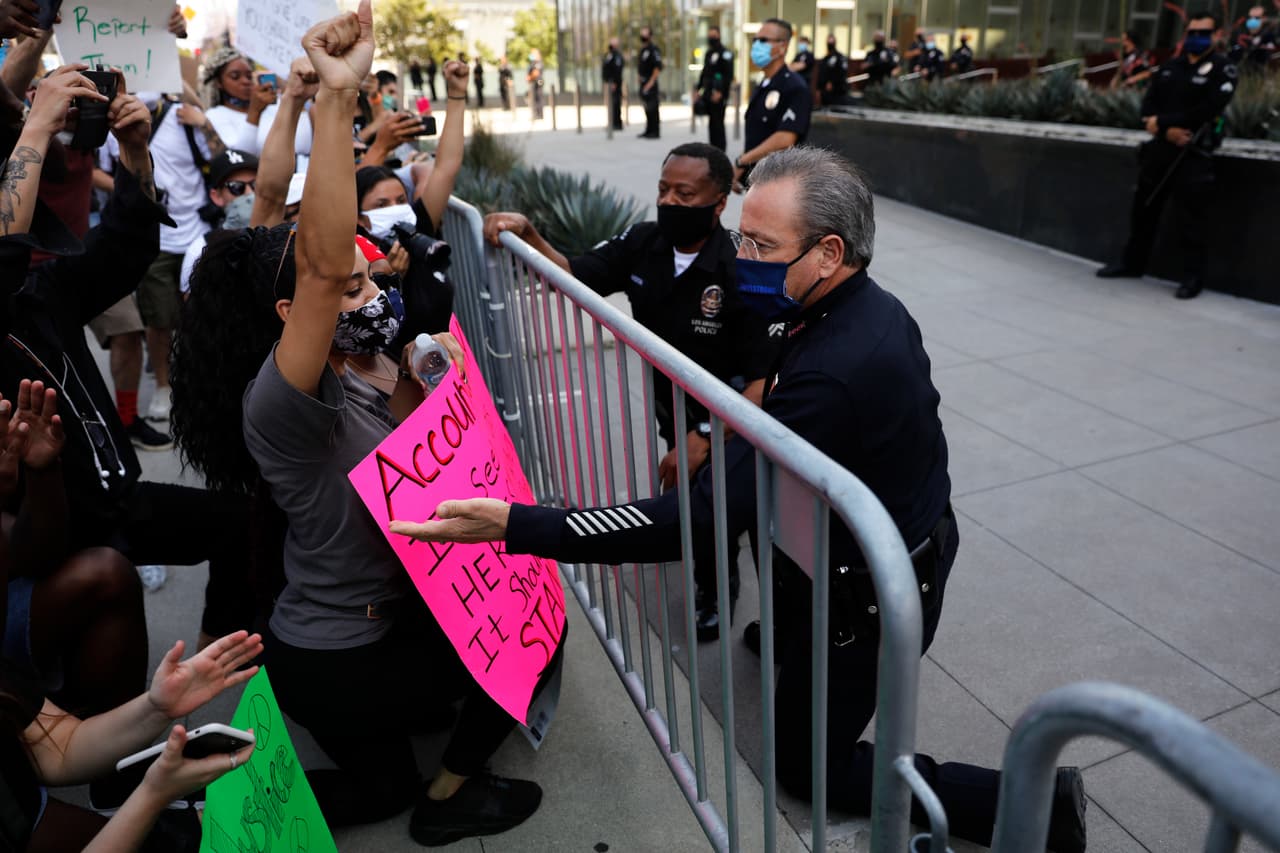 Las protestas en demanda de justicia en Los Ángeles han creado un tenso clima entre las comunidades, el LAPD y hasta el alcalde de Los Ángeles.
<br>
<br>En la imagen, Michel Moore, jefe de la policía de LAPD se arrodilla y estrecha su mano con los manifestantes, como símbolo de solidaridad.