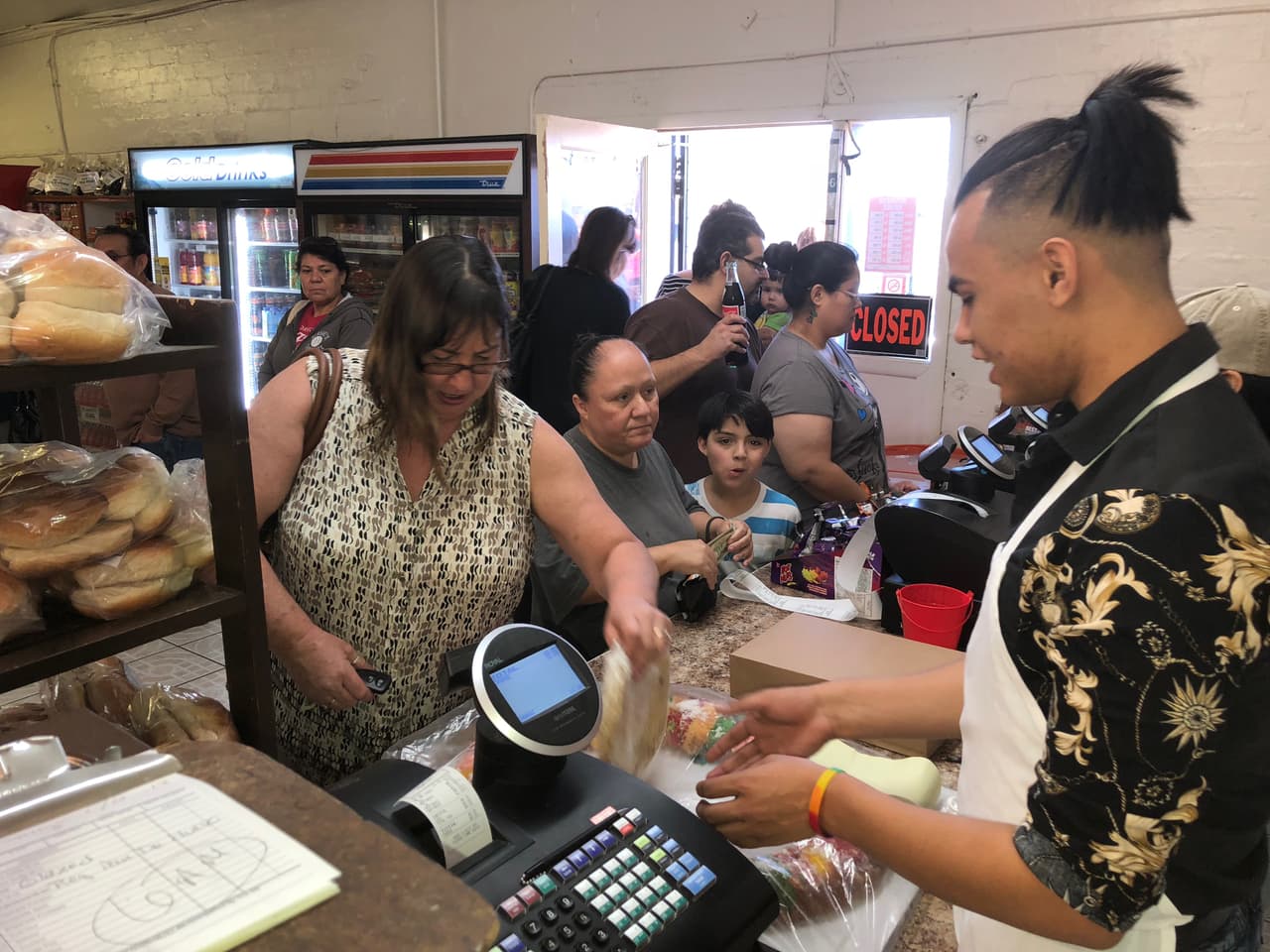 Decenas de personas llegan a la panadería a recoger sus pedidos de roscas.
