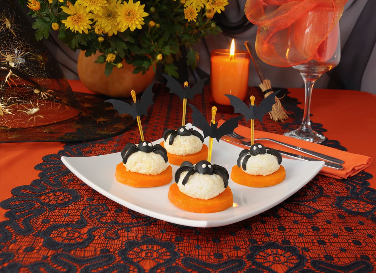 Definitivamente despertarás su apetito con estas curiosas bolas de queso con una base de calabaza y decoradas con frutos negros.