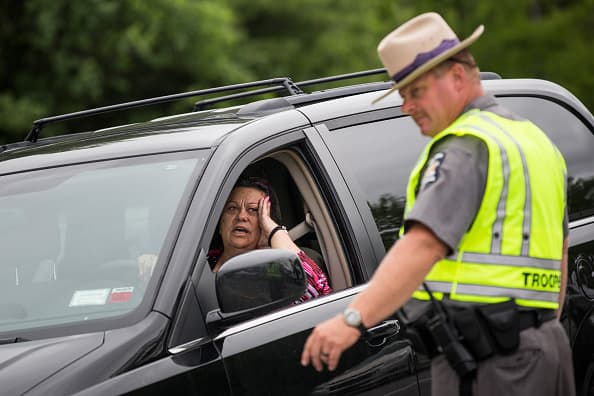 Agentes de orden están interrogando a conductores en un punto de inspección.