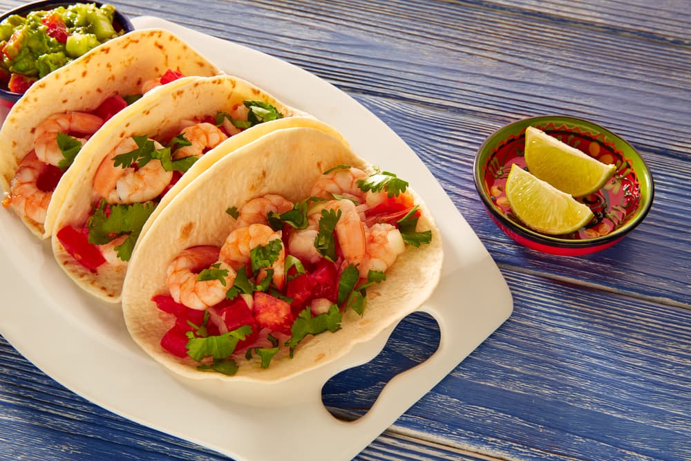 Tacos de camarón al tequila. Esta receta es digna de la cocina mexicana pues se trata de tacos y tequila, que son adoraciones de México. Lo mejor de esta receta es que es muy fácil, sólo debes picar cebolla y tomates para saltearlos un poco, después agregar los camarones y el tequila.
