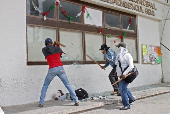 Otros portaban palos y comenzaron a romper los vidrios de las ventanas.