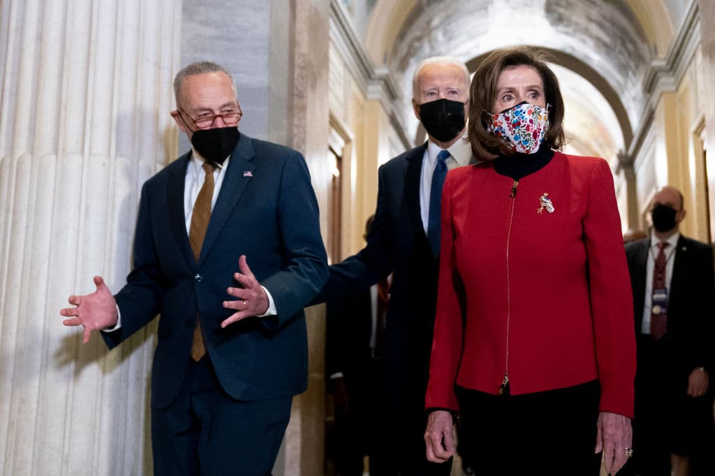 El presidente Joe Biden con los líderes demócratas en el Congreso, Chuck Schumer y Nancy Pelosi, entrando en la ceremonia del primer aniversario del asalto al Capitolio.