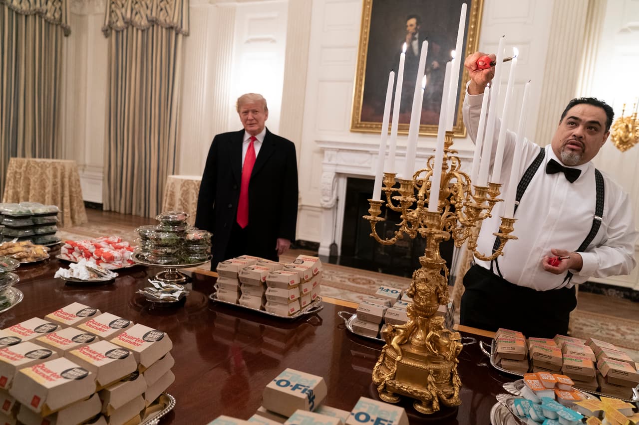 "Tenemos pizzas, tenemos 300 hamburguesas, muchas, muchas papas fritas, todas nuestras comidas favoritas", dijo Trump a los reporteros mientras un trabajador de la Casa Blanca encendía velas de un ostentoso candelabro junto a la comida.