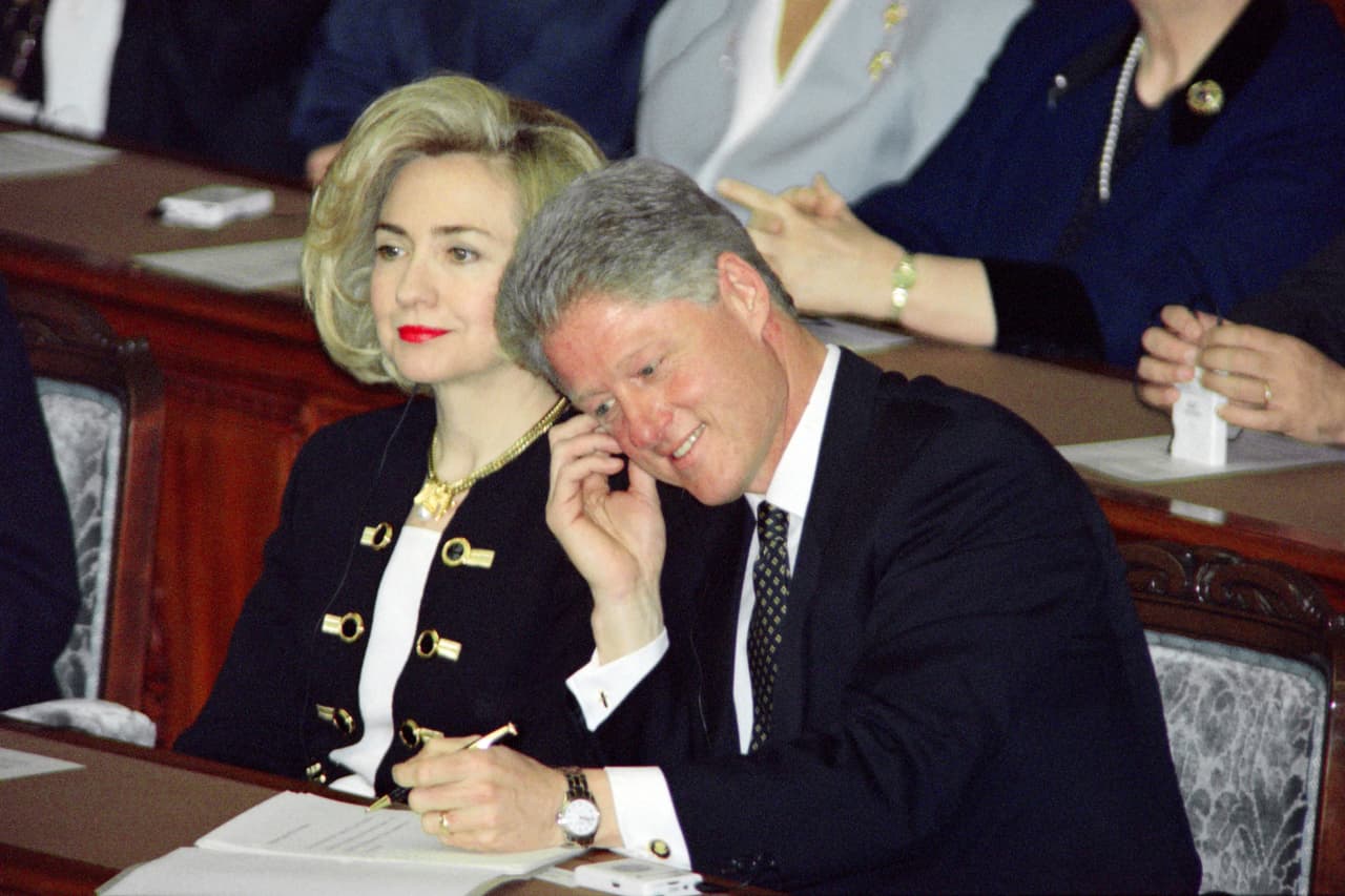 Conforme los años 90 fueron avanzando, la moda se empezó a volver un poco más recargada y brillante y el pelo volvió a recobrar el volumen. Hillary Clinton no iba a ser la excepción de esa tendencia. Las chaquetas cortas a la cintura de cuello redondo y de herrajes tipo militar pasaron de la casa Blanca a la moda más común de la calle. YOSHIKAZU TSUNO/AFP/Getty Images