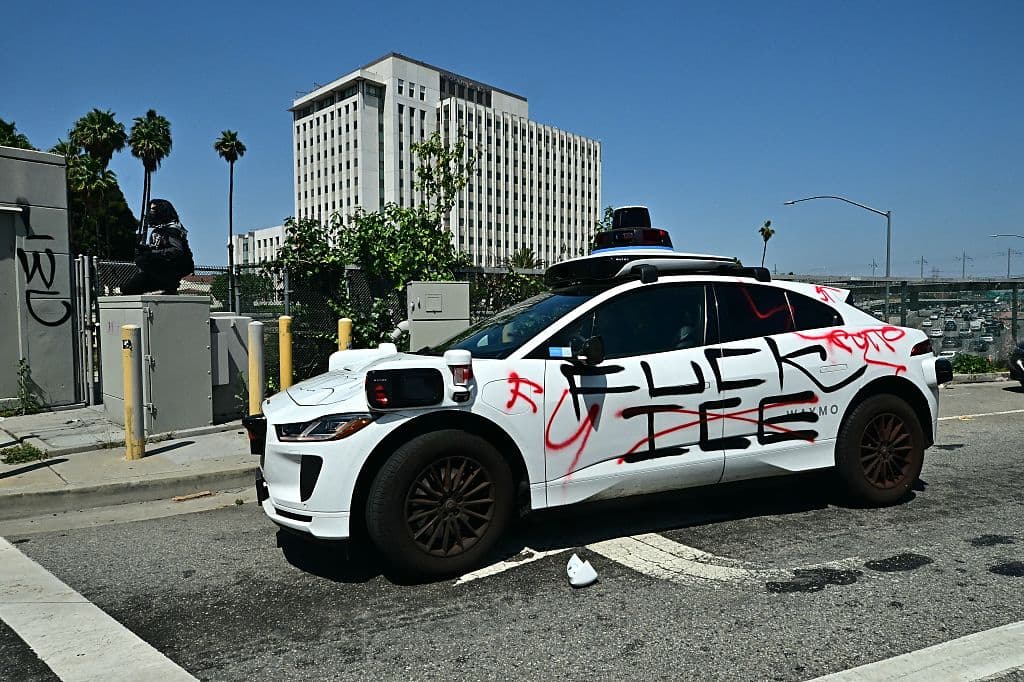 Después de dos días de intensas manifestaciones en Los Ángeles, este domingo un auto de Waymo frente al centro de detención de ICE en Los Ángeles lucía mensajes en contra de ICE, que alguien le pintó con pintura de espray.