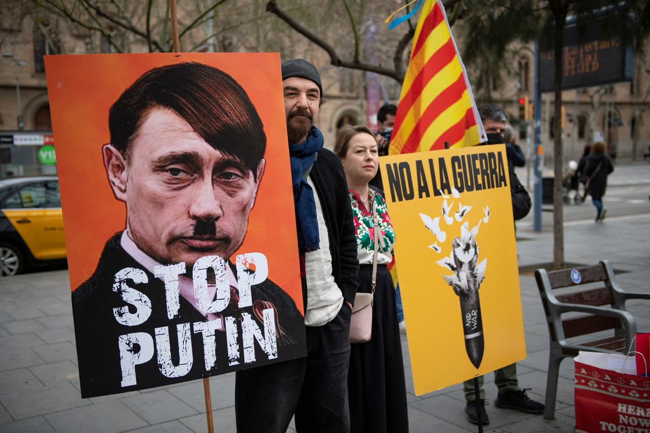 Un manifestante sostiene un cartel en el que se representa al presidente ruso como Adolf Hitler y se lee "Para a Putin" durante una protesta contra la operación militar rusa en Ucrania, en Barcelona, el 26 de febrero de 2022.
