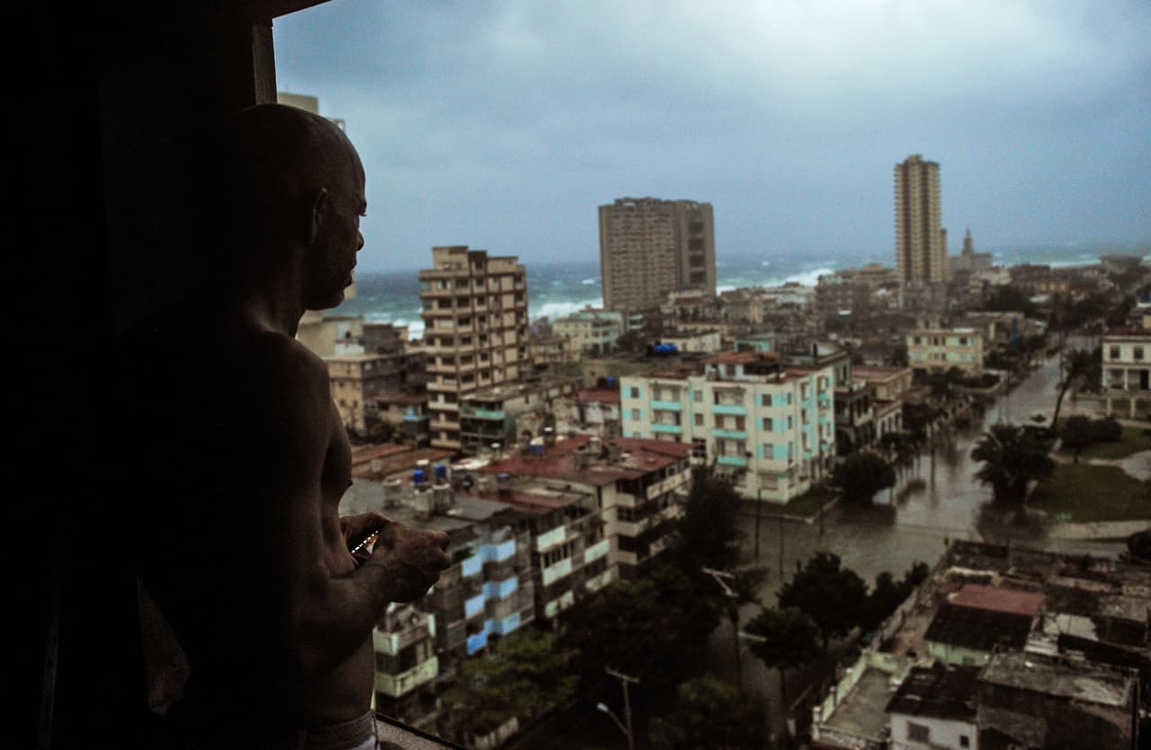 Al menos 1,5 millones de personas fueron evacuadas en la isla, donde el viento tumbó árboles y tendidos eléctricos. Un residente mira las calles inundadas de La Habana desde su ventana.