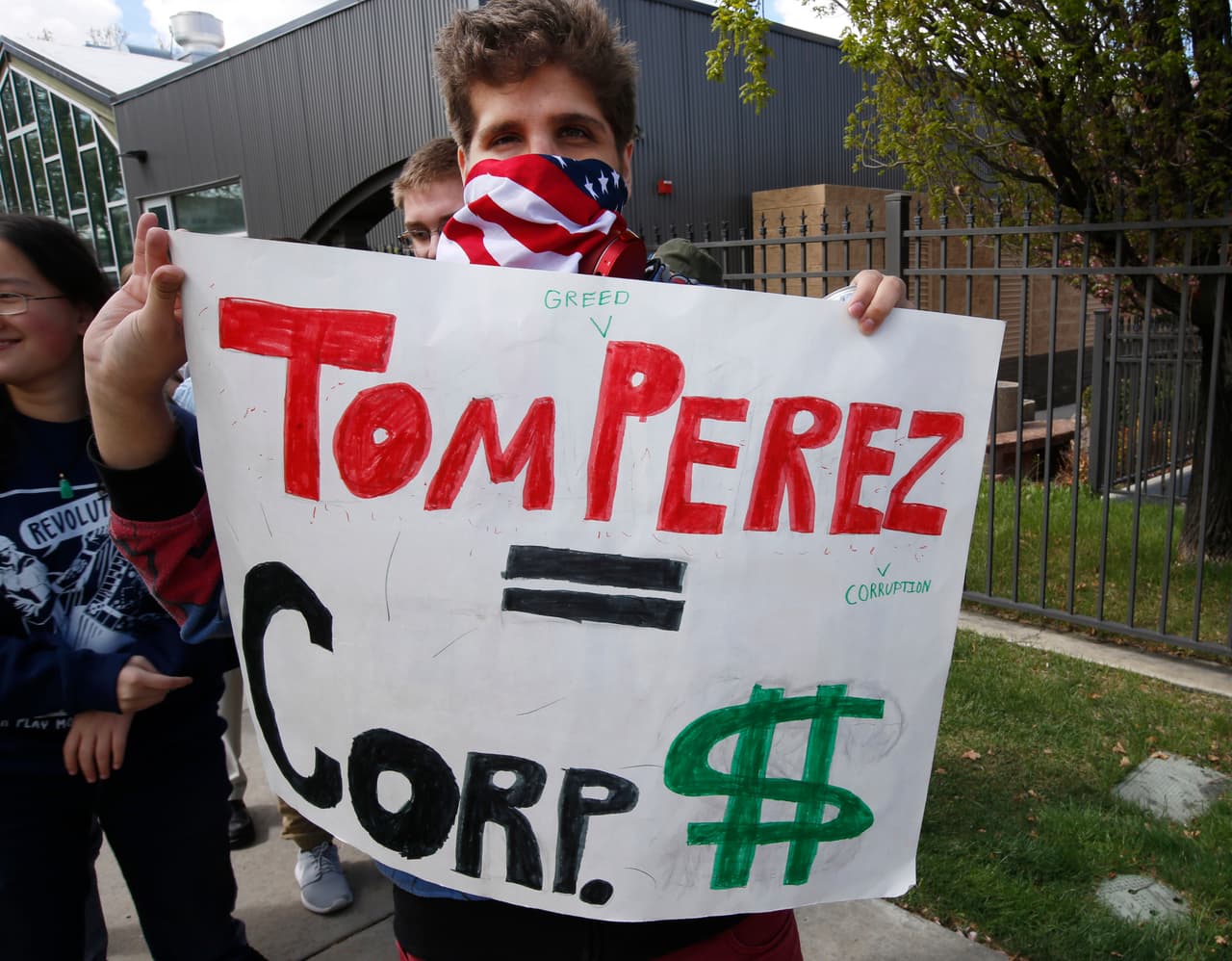 Un detractor de Pérez muestra un cartel en el Rail Event Center en Salt Lake City, Utah, antes de su evento conjunto con Bernie Sanders.