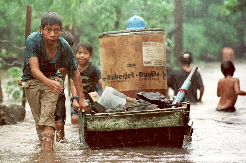 Un niño arrastra sus pertenencias por una calle inundada el 31 de octubre de 1998 en Managua, Nicaragua.