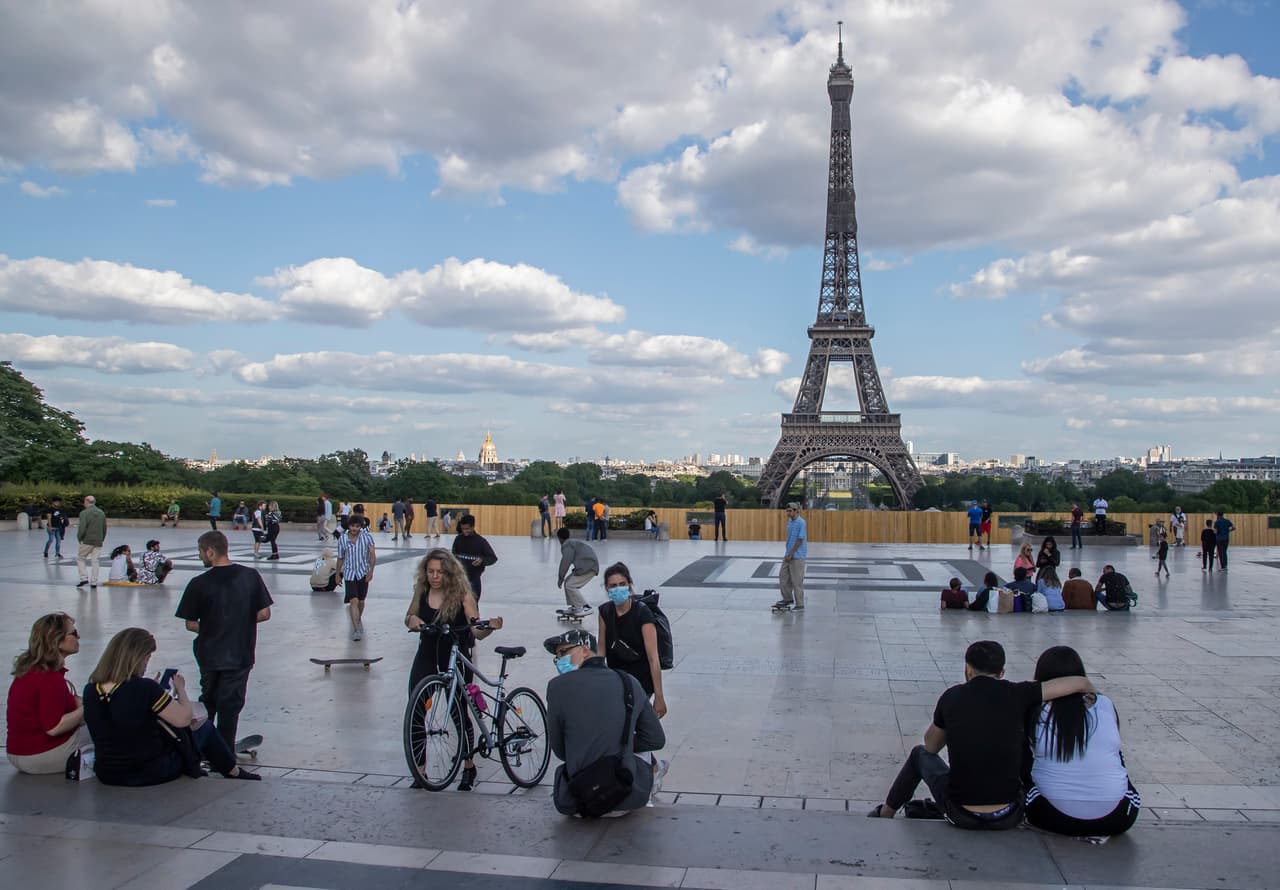 Decenas de personas en la plaza Trocadero, cerca de la Torre Eiffel en París. Aunque Francia levanta gradualmente las medidas de confinamiento los parques permanecen cerrados, por esto los residentes han colmado los espacios a largo del río Sena. 25 de mayo.
