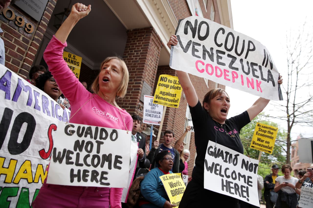 Medea Benjamin (a la inquierda) y Ariel Gold (a la derecha) gritan mensajes a favor del mandatario venezolano Nicolás Maduro a las afueras de la sede de la embajada en Washington.