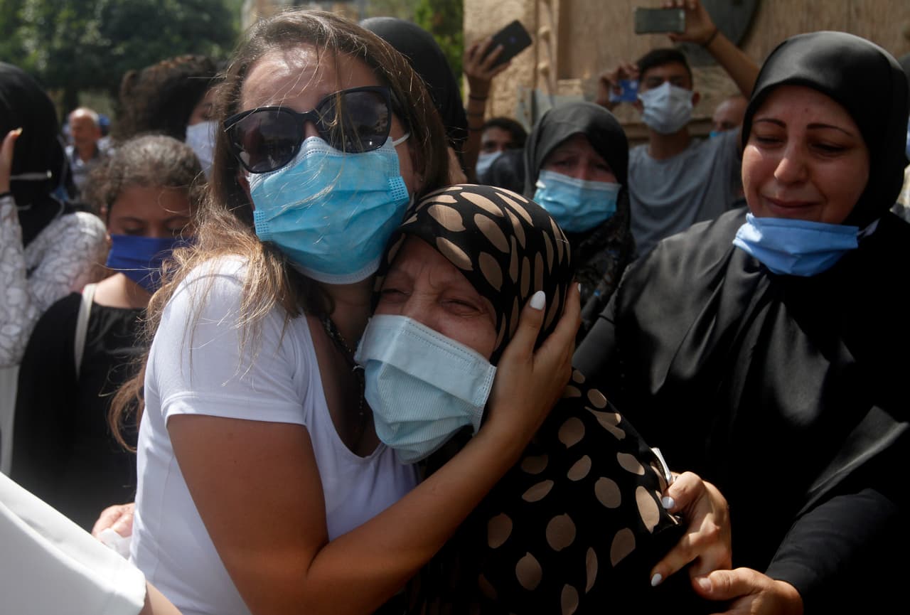 Familiares del teniente del ejército libanés Ayman Noureddine, quien murió por la explosión que golpeó el puerto de Beirut, lloran durante su procesión fúnebre. Los equipos de rescate todavía buscan cuerpos en los escombros, cuatro días después de la detonación masiva que estremeció la capital de Líbano.
