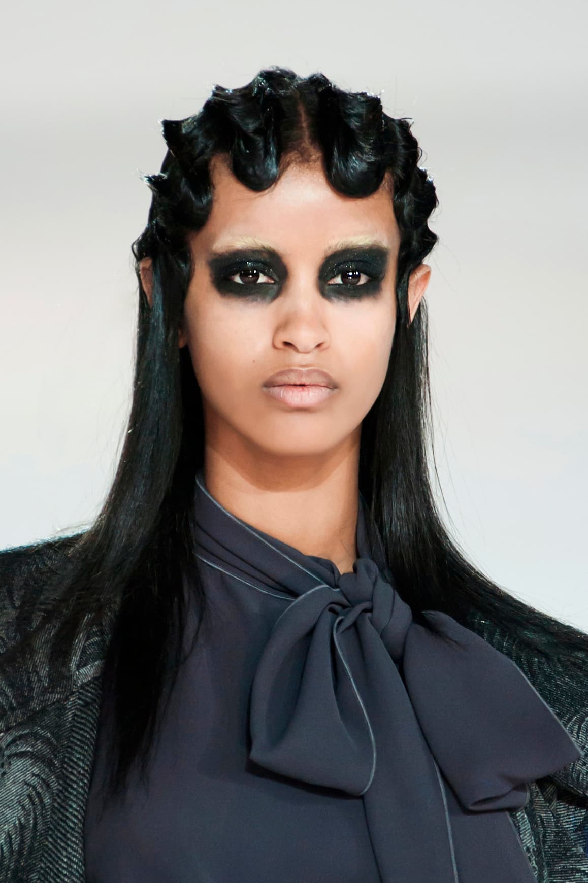 El resultado del maquillaje de 
<a href="http://www.vogue.com/fashion-shows/fall-2016-ready-to-wear/marc-jacobs/slideshow/collection">Marc Jacobs</a> no es aterrador, pero estos ojos saturados de sombra negra solo valen para asistir a una fiesta de disfraces. La ceja se borra (con ayuda de una base de maquillaje) para lograr un efecto más dramático.
<br>