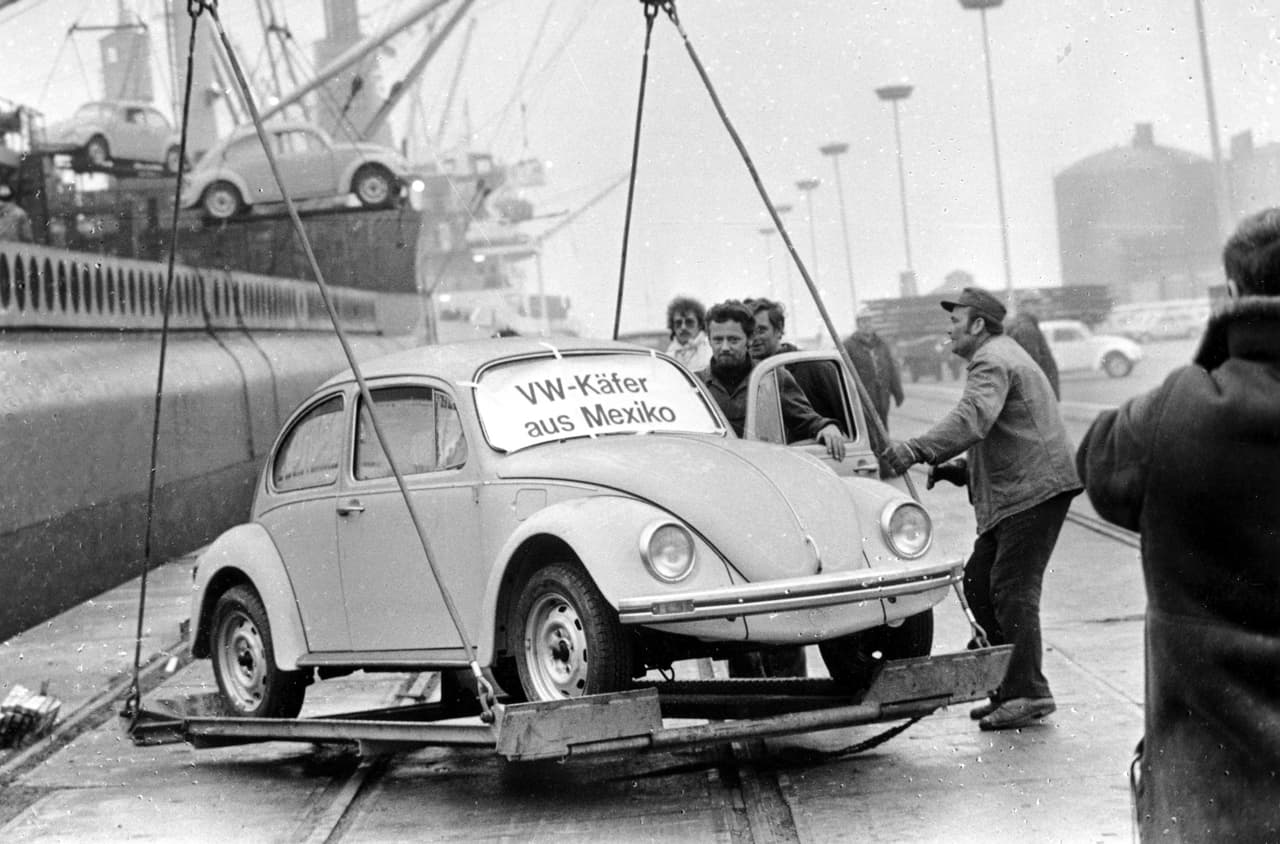 En 1967 México ya era sede de una fábrica de la empresa automotriz donde se fabricaba el auto escarabajo. Al descontinuarse en Alemania, el país de América del Norte continuó produciéndolos hasta el año 2003 con su diseño original con silueta redondeada, asientos para cuatro o cinco personas, parabrisas casi vertical y el motor en la parte trasera. La foto muestra el momento de descarga de un escarabajo en el puerto de Emden, Alemania, proveniente de México.
<br>