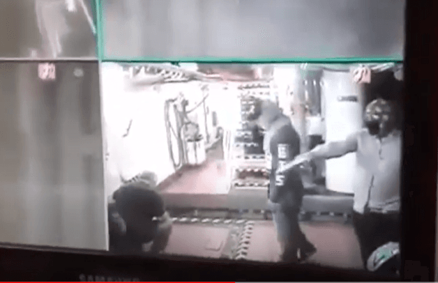 A screen grab of surveillance video from a pirate attack in April on the offshore supply vessel, Remas, in the Gulf of Mexico. Two pirates armed with pistols force the crew on the ground.