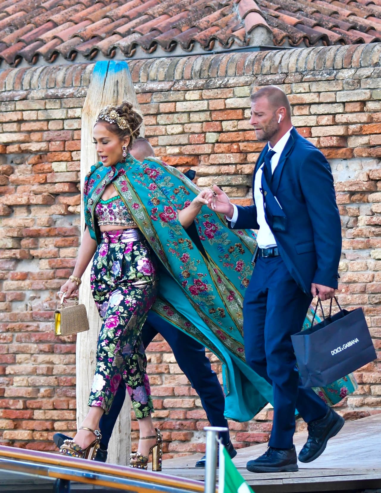 El conjunto Dolce & Gabbana 
<b><a href="https://www.univision.com/famosos/jennifer-lopez-y-sus-looks-de-pelicula-video" target="_blank">consistía en una capa de flores verde azulado y rosa</a></b> con mangas abullonadas y un bralette.
<br>