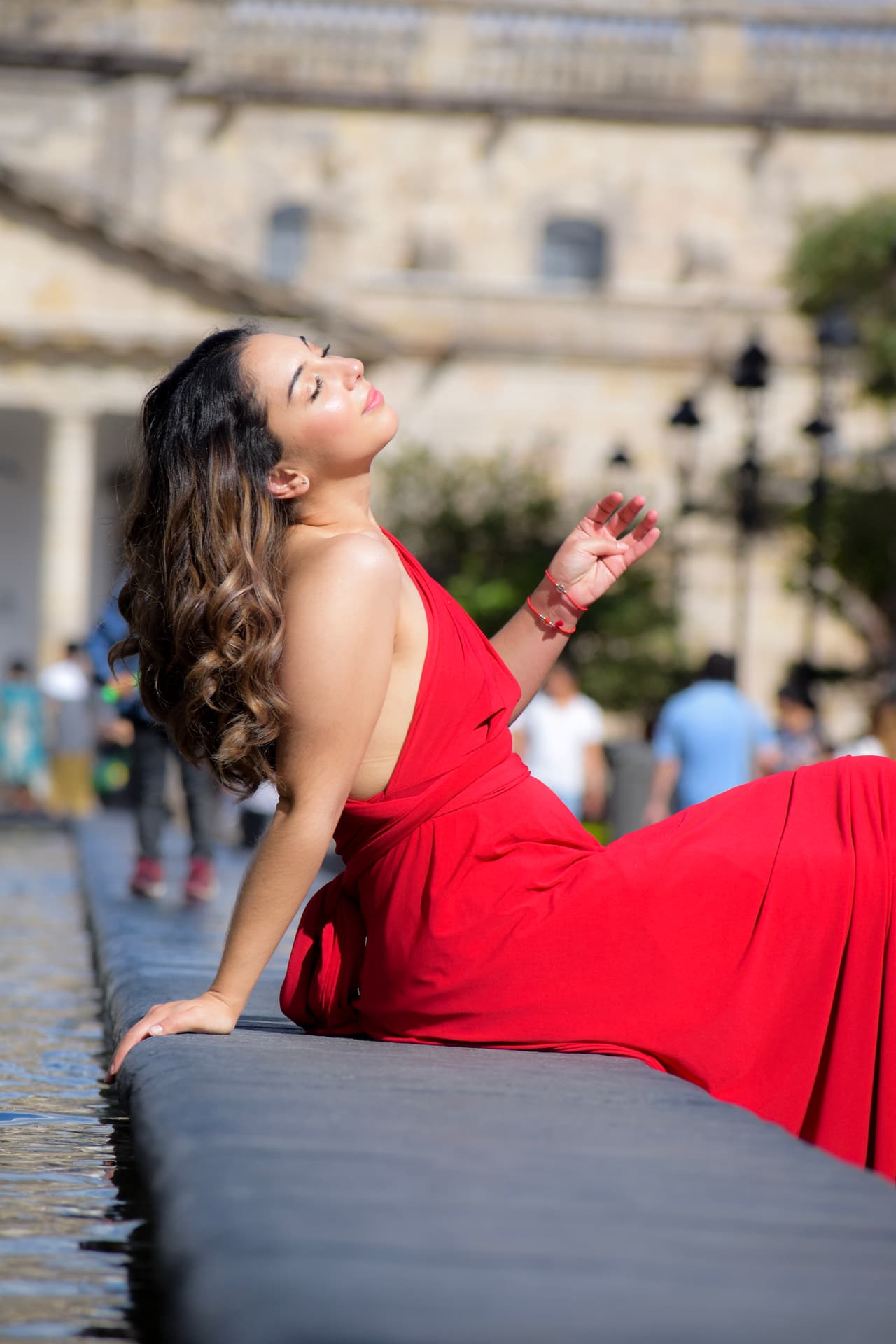 El rojo de su vestido, con el sol de plena tarde y el agua que llegaba a salpicar de la fuente, la hicieron sentir como toda una super modelo.