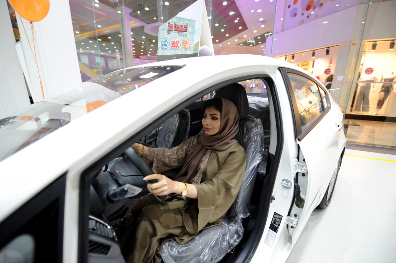 Otras escena inusual. El reino de Arabia Saudita anunció que a partir de junio las mujeres podrán conducir, lo que levantaría la única prohibición de este tipo para mujeres en el mundo. En la fotografía, una mujer prueba el lado del conductor de un auto en una exposición en Yeda.