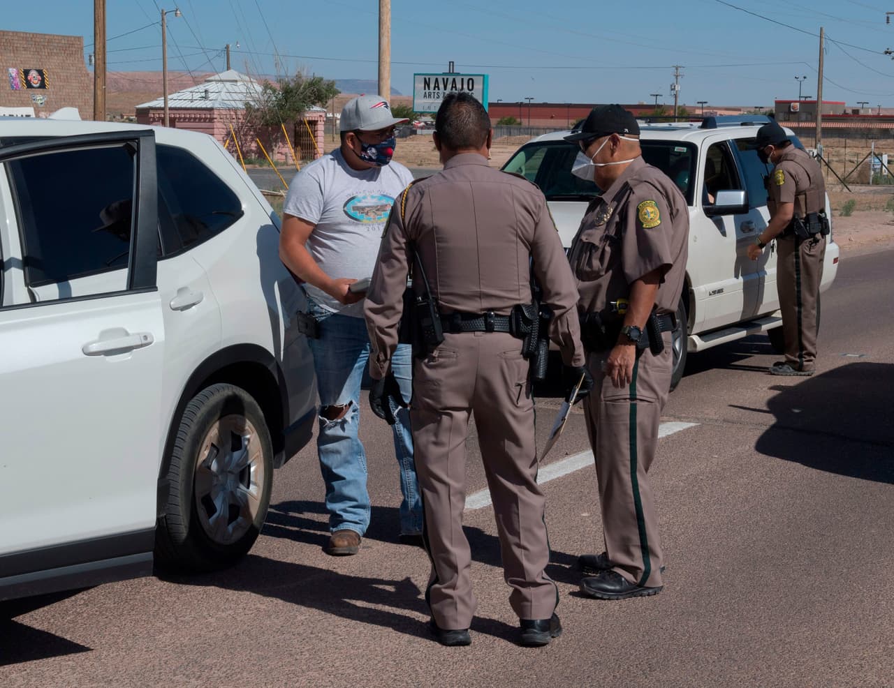 Oficiales de policía de la Nación Navajo interrogan a los conductores durante el toque de queda de 57 horas impuesto para tratar de detener la propagación del virus del coronavirus, en la ciudad de Chinle, Arizona. El presidente de la Nación Navajo, Jonathan Nez, dijo a AFP en una entrevista que de los $8 mil millones prometidos a las tribus estadounidenses en un paquete de estímulo de $2.2 billones aprobado a fines de marzo, el primer envió llegó hace poco más de una semana.