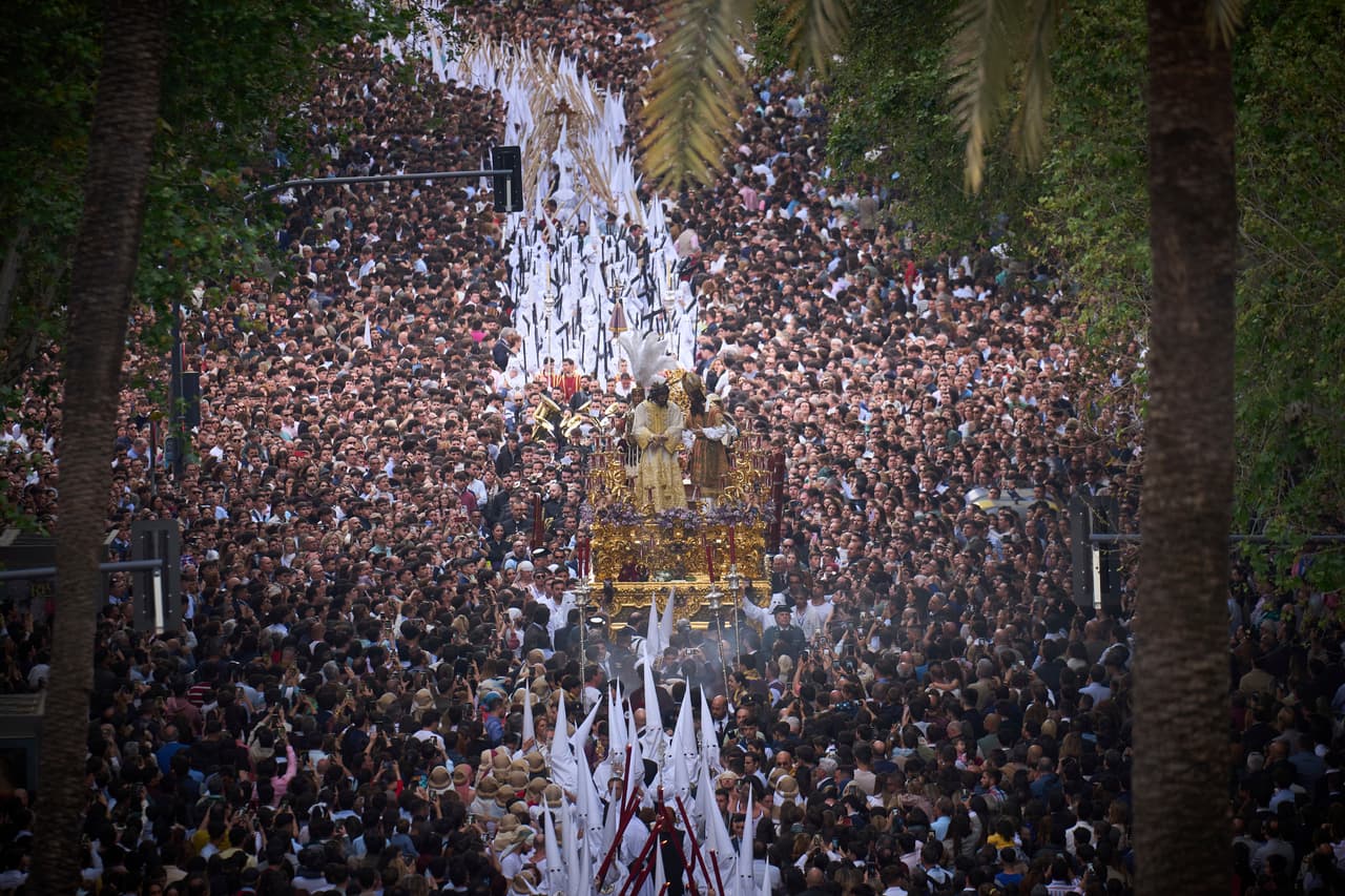 Fieles observan una procesión de Semana Santa de los penitentes de la hermandad 'San Gonzalo' en Sevilla, España, el 14 de abril de 2025.